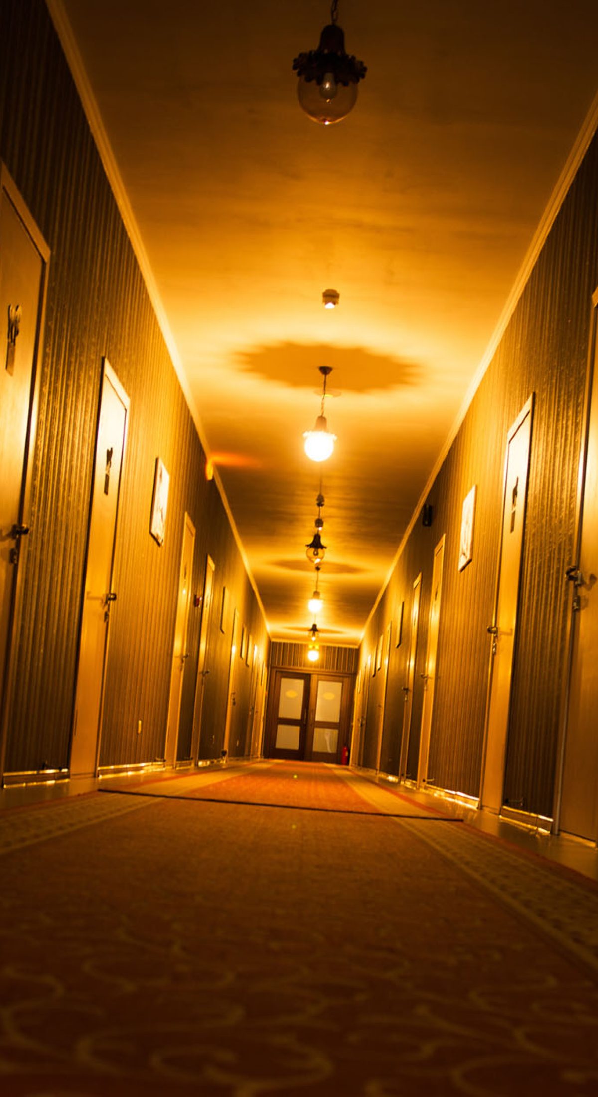 long dark vintage motel corridor with closed doors